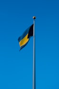yellow and black flag under blue sky during daytime