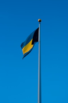 yellow and black flag under blue sky during daytime