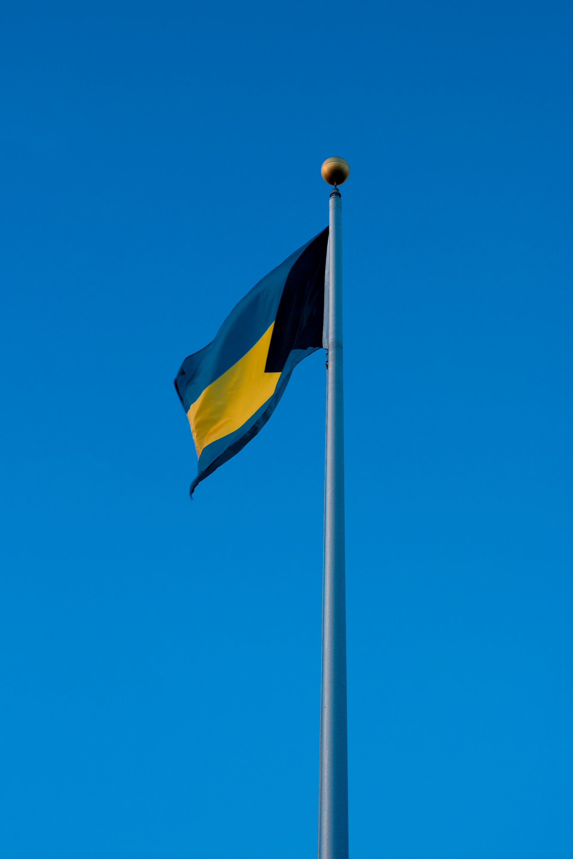 yellow and black flag under blue sky during daytime