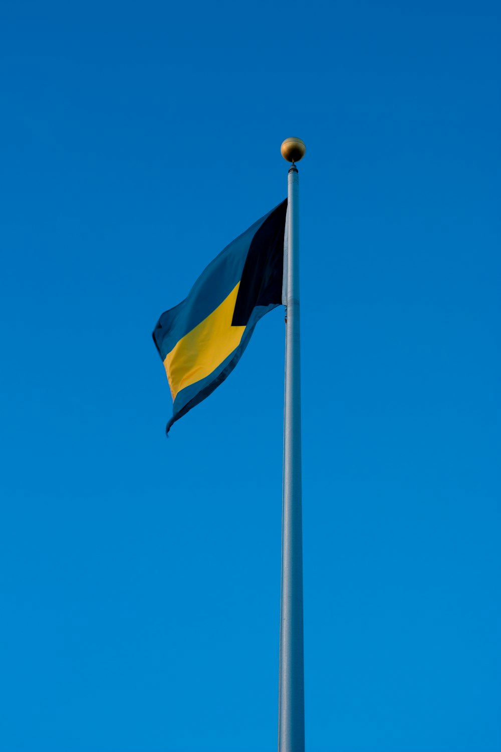 Bandera amarilla y negra bajo el cielo azul durante el día