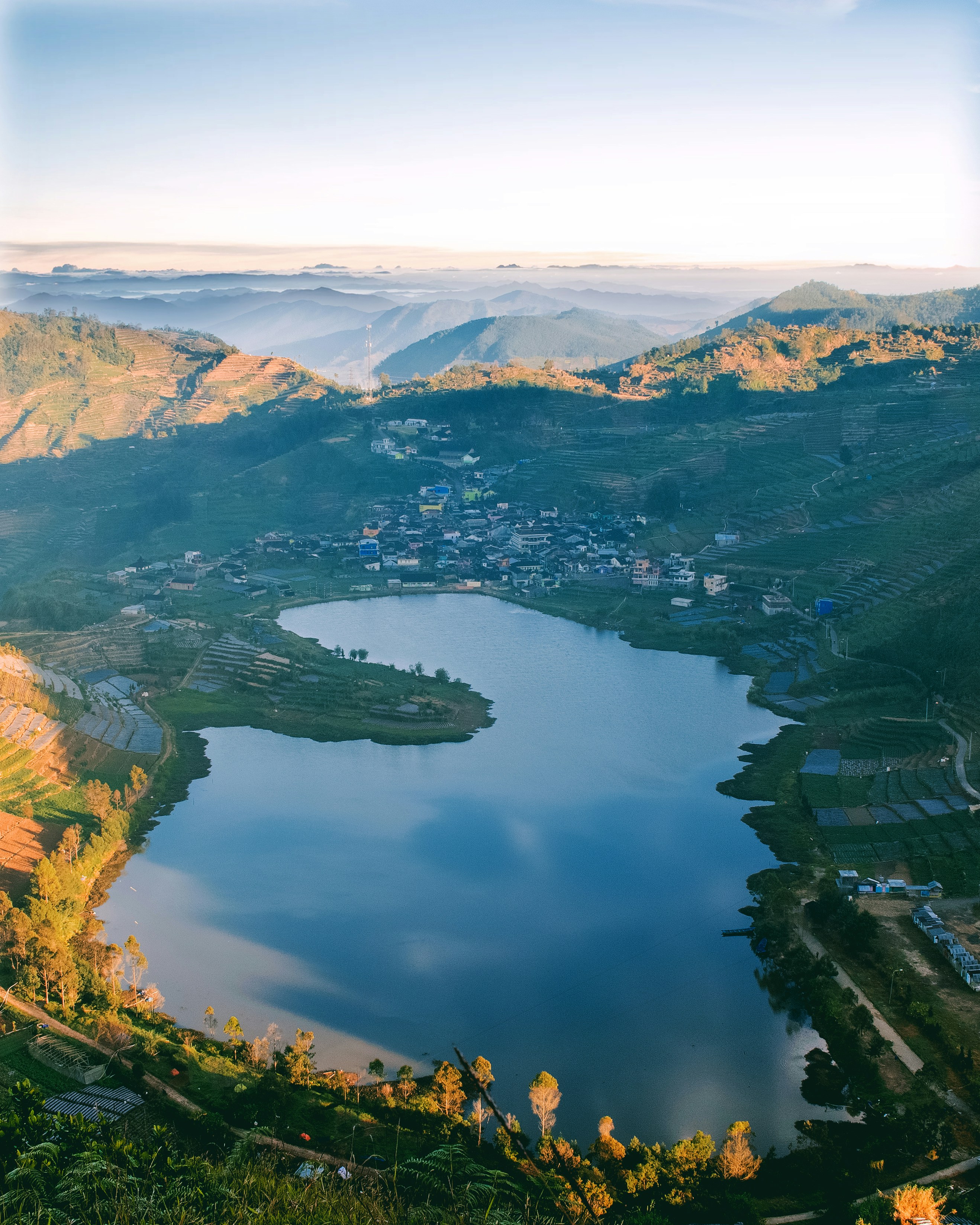 vista aérea do lago cercado por montanhas durante o dia