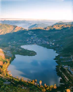 aerial view of lake surrounded by mountains during daytime