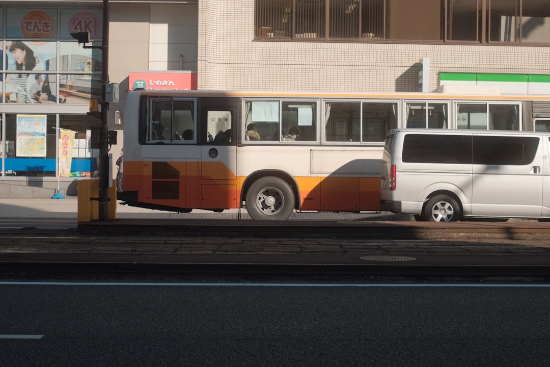 orange and white bus on road during daytime