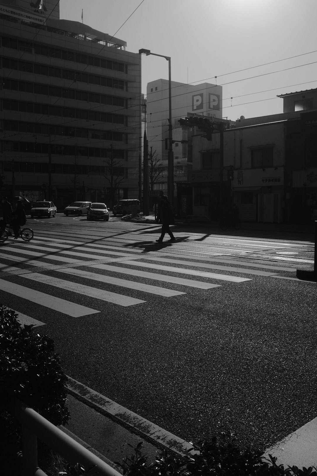 grayscale photo of man walking on pedestrian lane