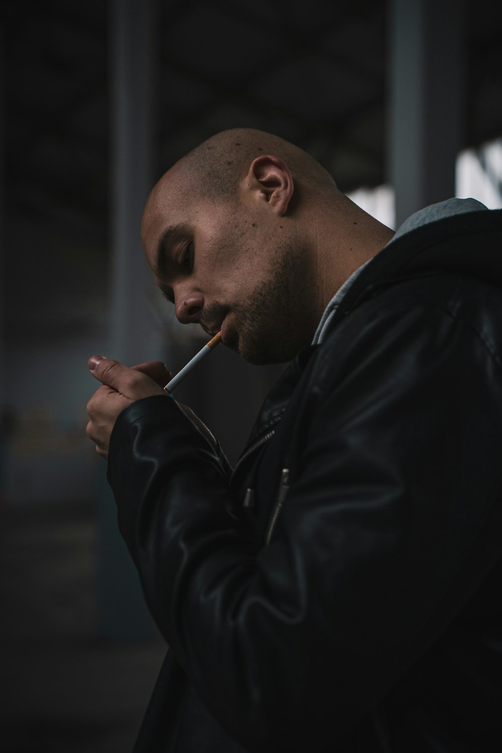 man in black leather jacket smoking cigarette