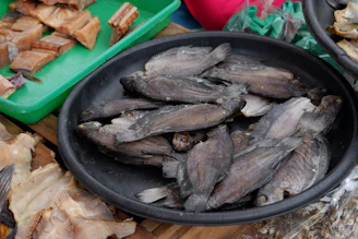 Close-up of shiny golden bollo dry fish neatly arranged on a rustic wooden tray.
