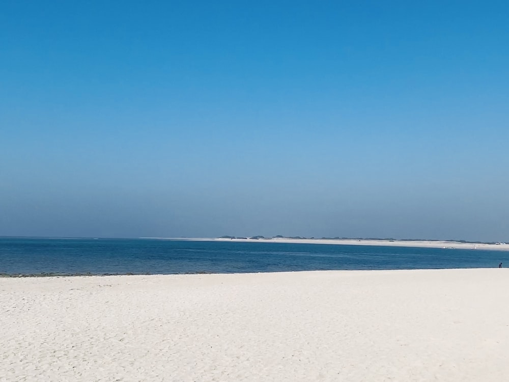 white sand beach under blue sky during daytime