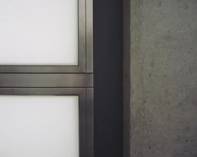 Close-up of textured concrete surface contrasted with smooth black metal framing.