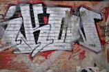 A bold graphic detail of youngka's logo spray-painted on a worn brick wall.