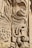 Detailed stone carving with intricate swirling and floral patterns, showcasing expert craftsmanship. The texture and shadowing create depth and highlight the artistic features.