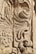 Detailed stone carving with intricate swirling and floral patterns, showcasing expert craftsmanship. The texture and shadowing create depth and highlight the artistic features.