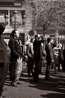 A diverse group of adults dressed in casual and formal seasonal outfits in a city setting.