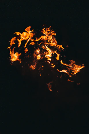 Close-up of bright orange fire flickering against a dark background
