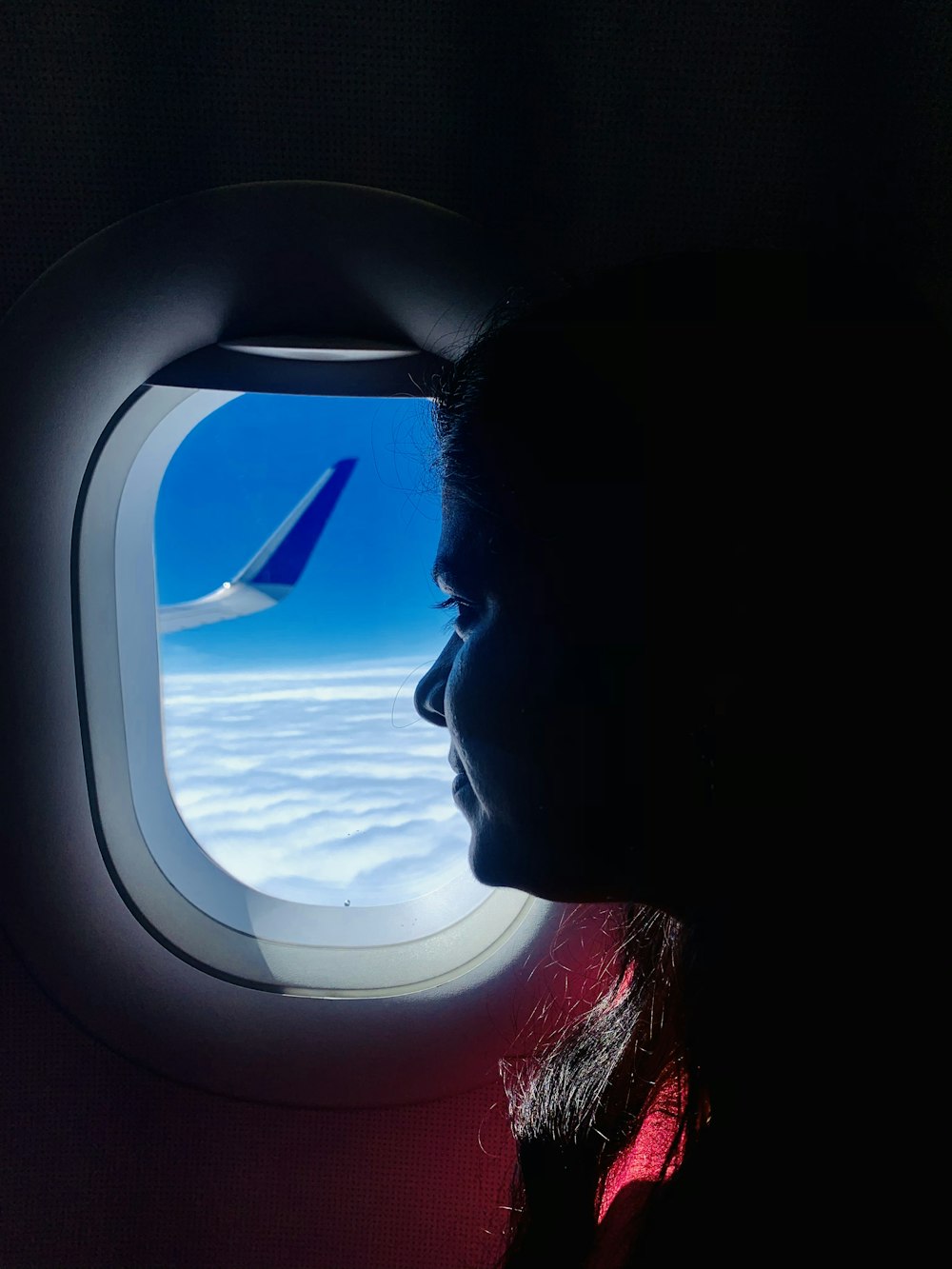 飛行機の窓を眺める女性