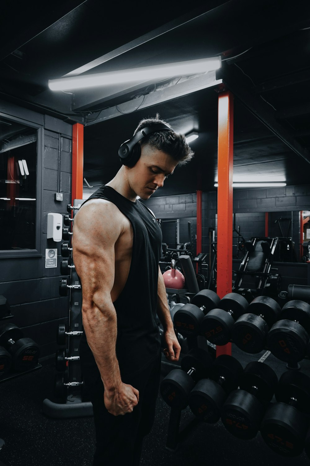 Hombre con camiseta sin mangas negra con auriculares negros