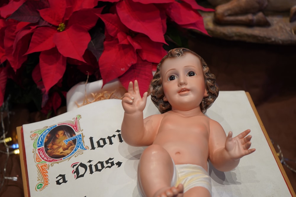 baby lying on red and white textile