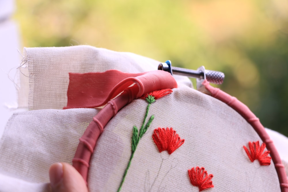 person holding red and white textile