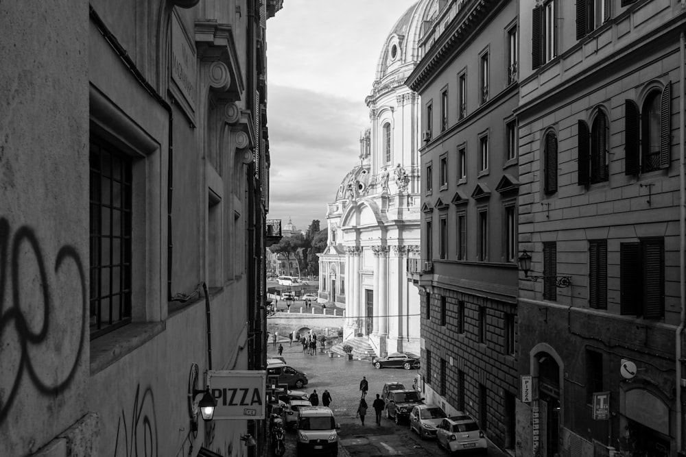 grayscale photo of people walking on street near buildings