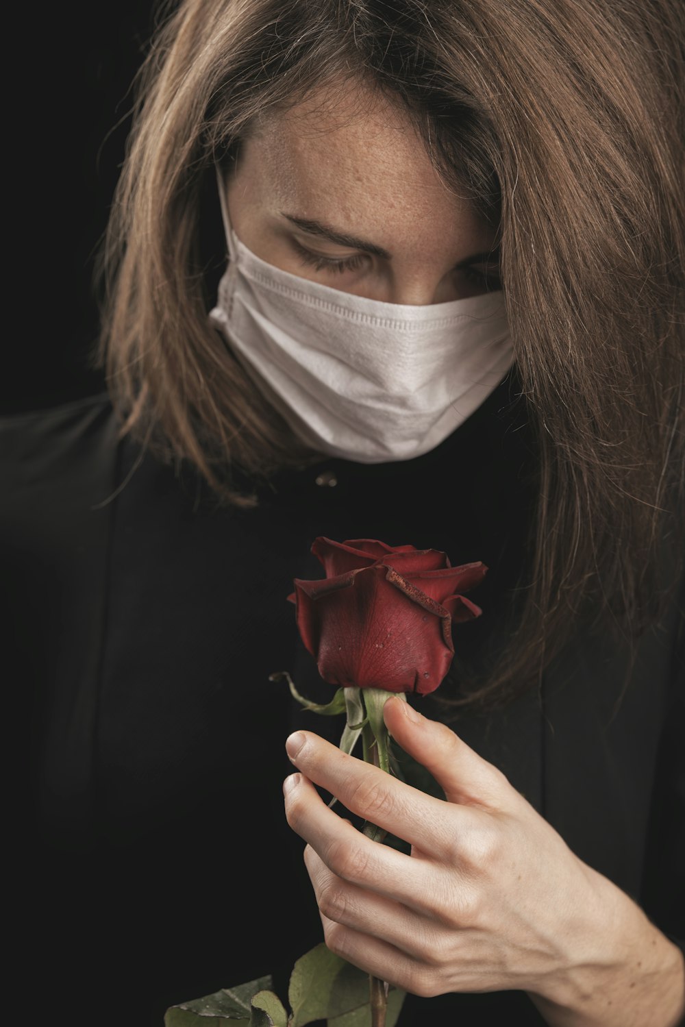 woman holding red rose with face