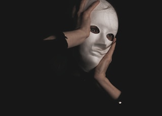 person in black long sleeve shirt covering face with face
