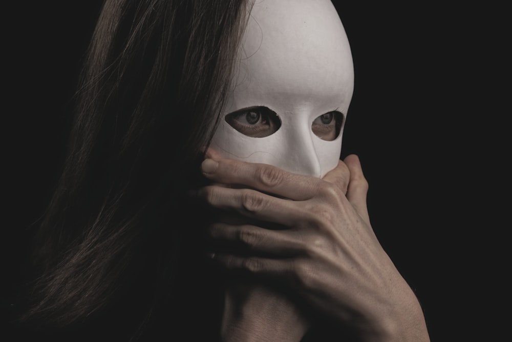woman covering face with white mask