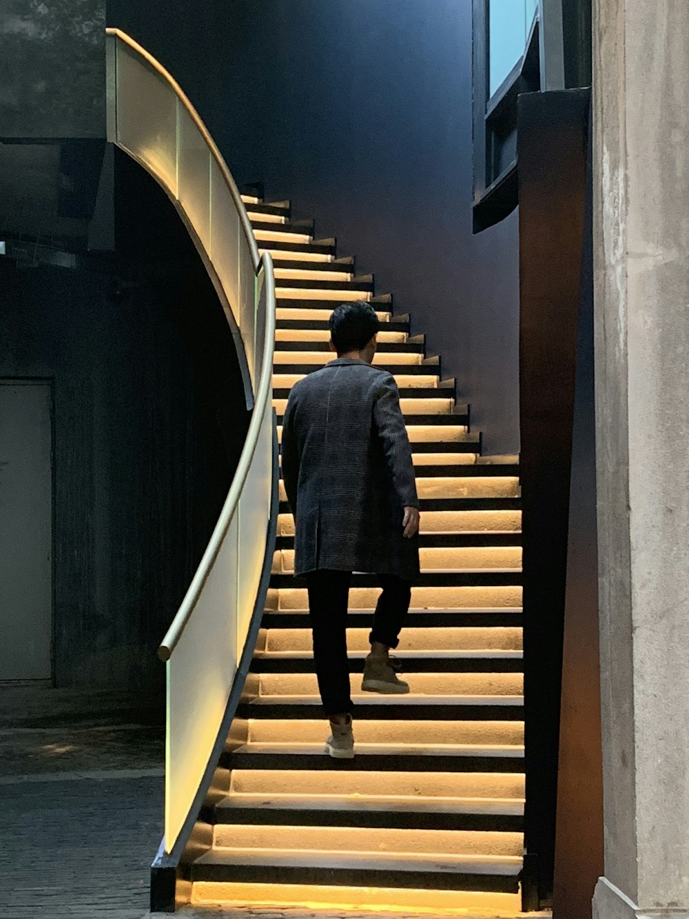 man in black coat walking on the stairs