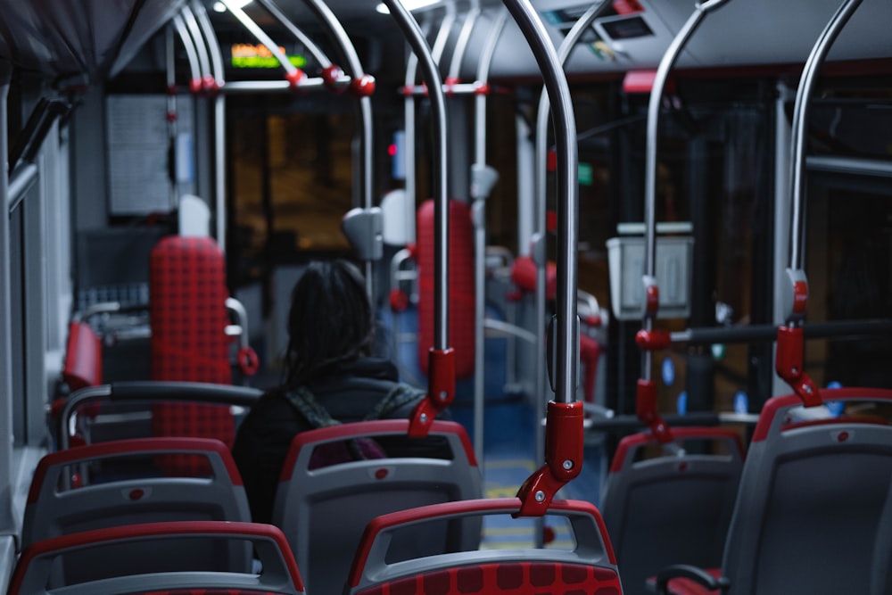 people sitting on red and black bus seat