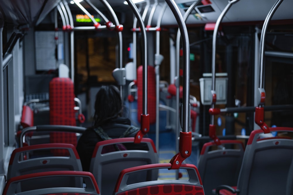 Persone sedute sul sedile dell'autobus rosso e nero