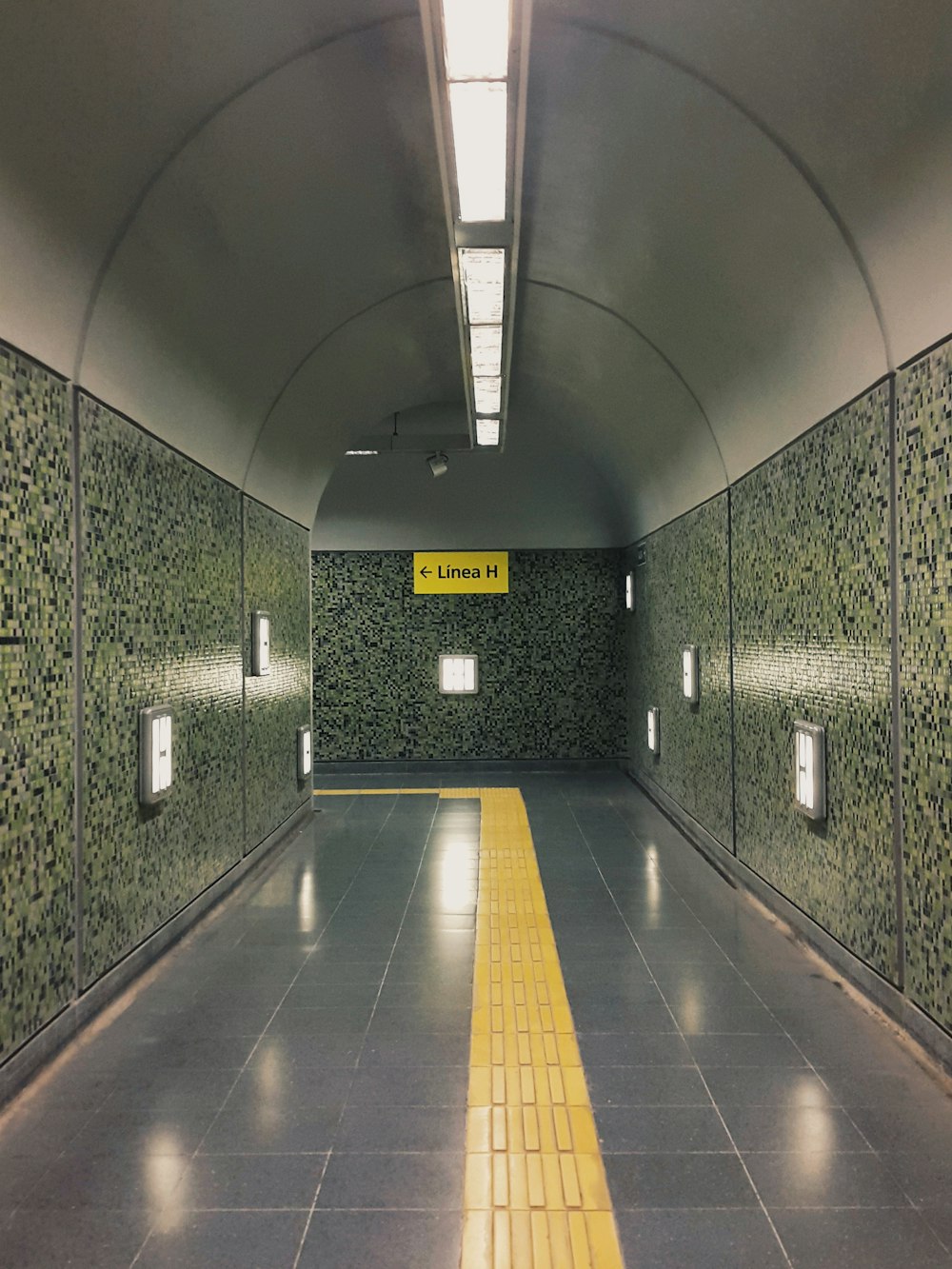 grauer und gelber Tunnel mit gelben und weißen Bodenfliesen