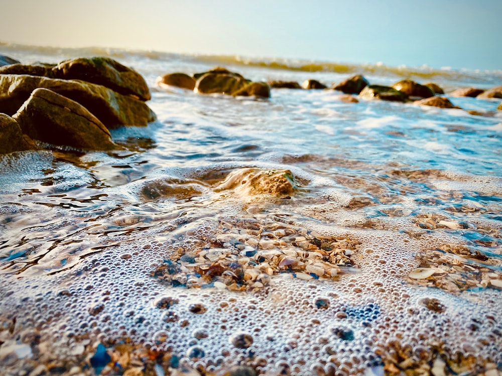 Braune Felsformation am weißen Sandstrand tagsüber