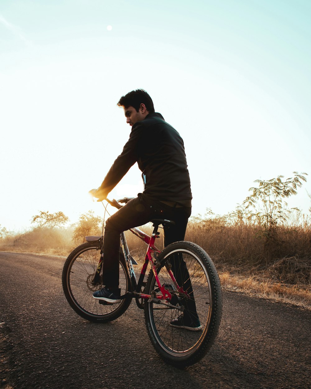 man in black shirt riding on bicycle during daytime