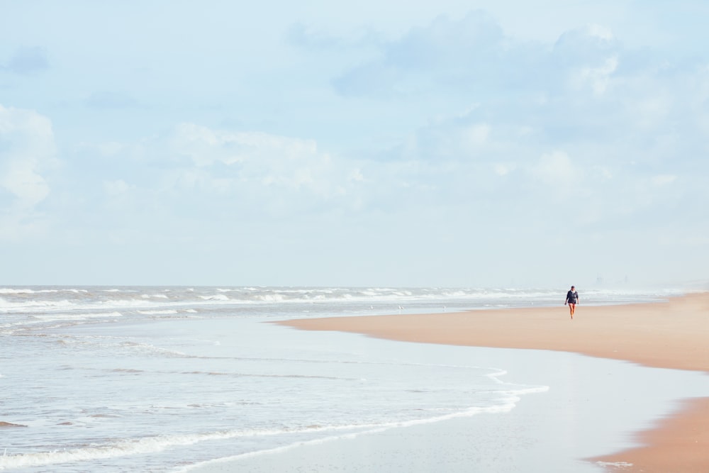 person walking on beach during daytime