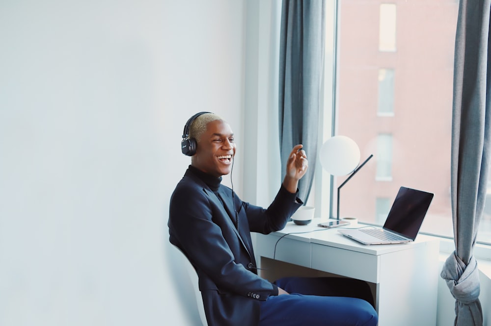 man in black long sleeve shirt sitting on blue chair