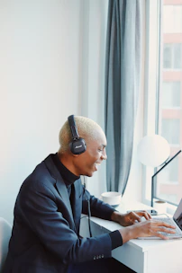 A student attending a virtual class on a laptop, smiling and engaged.