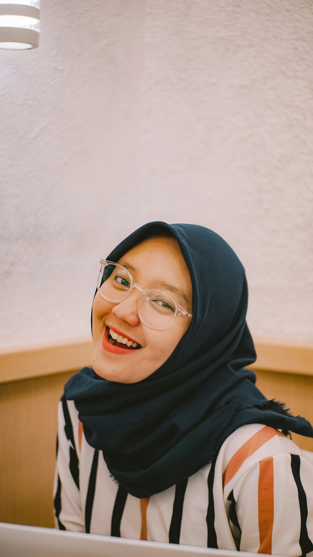 woman in blue hijab and black framed eyeglasses