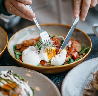person holding stainless steel fork and knife