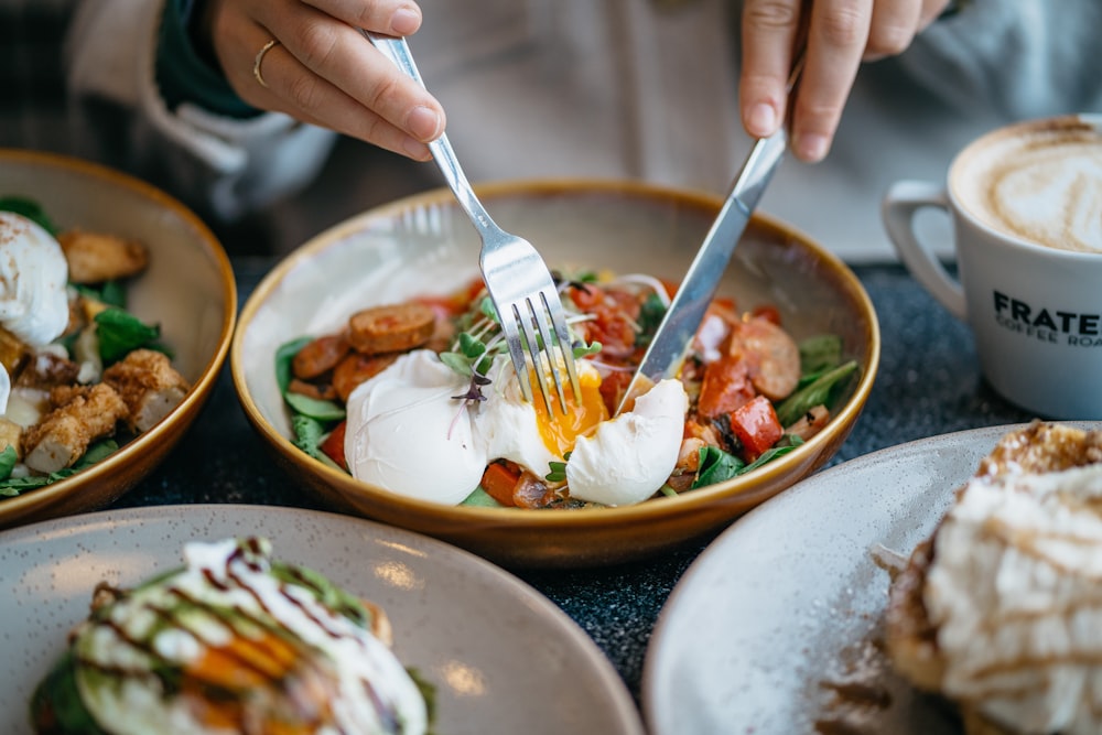 person holding stainless steel fork and knife