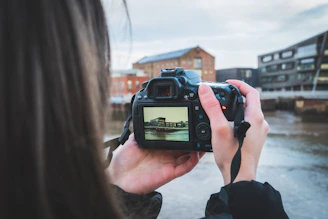 person holding black dslr camera during daytime