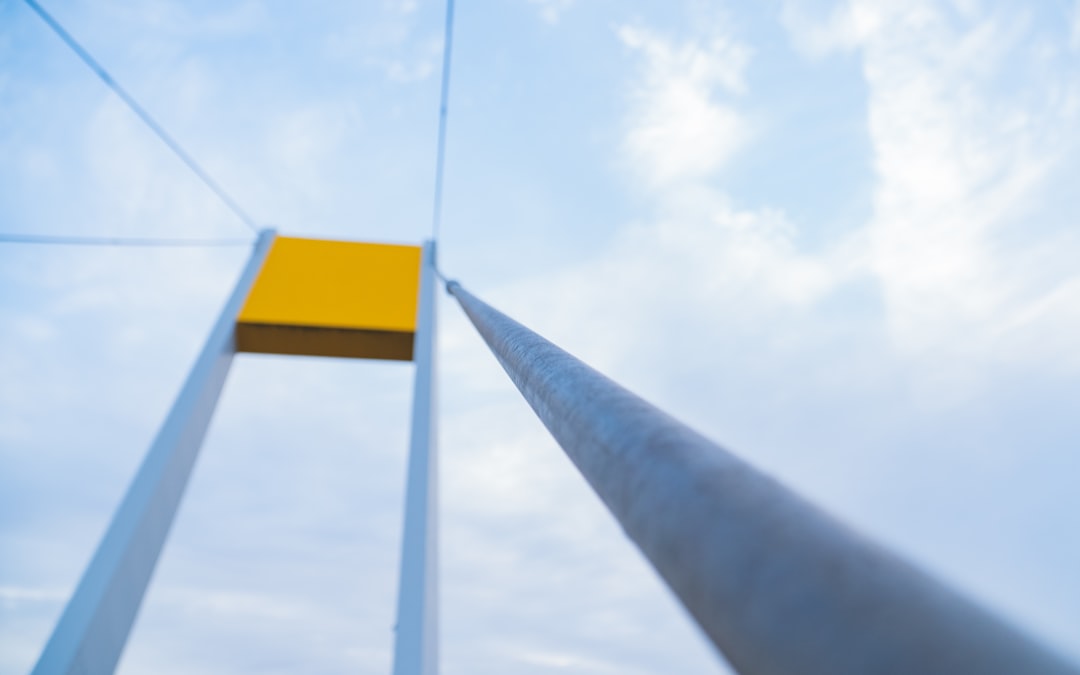 yellow and white road sign under white clouds during daytime