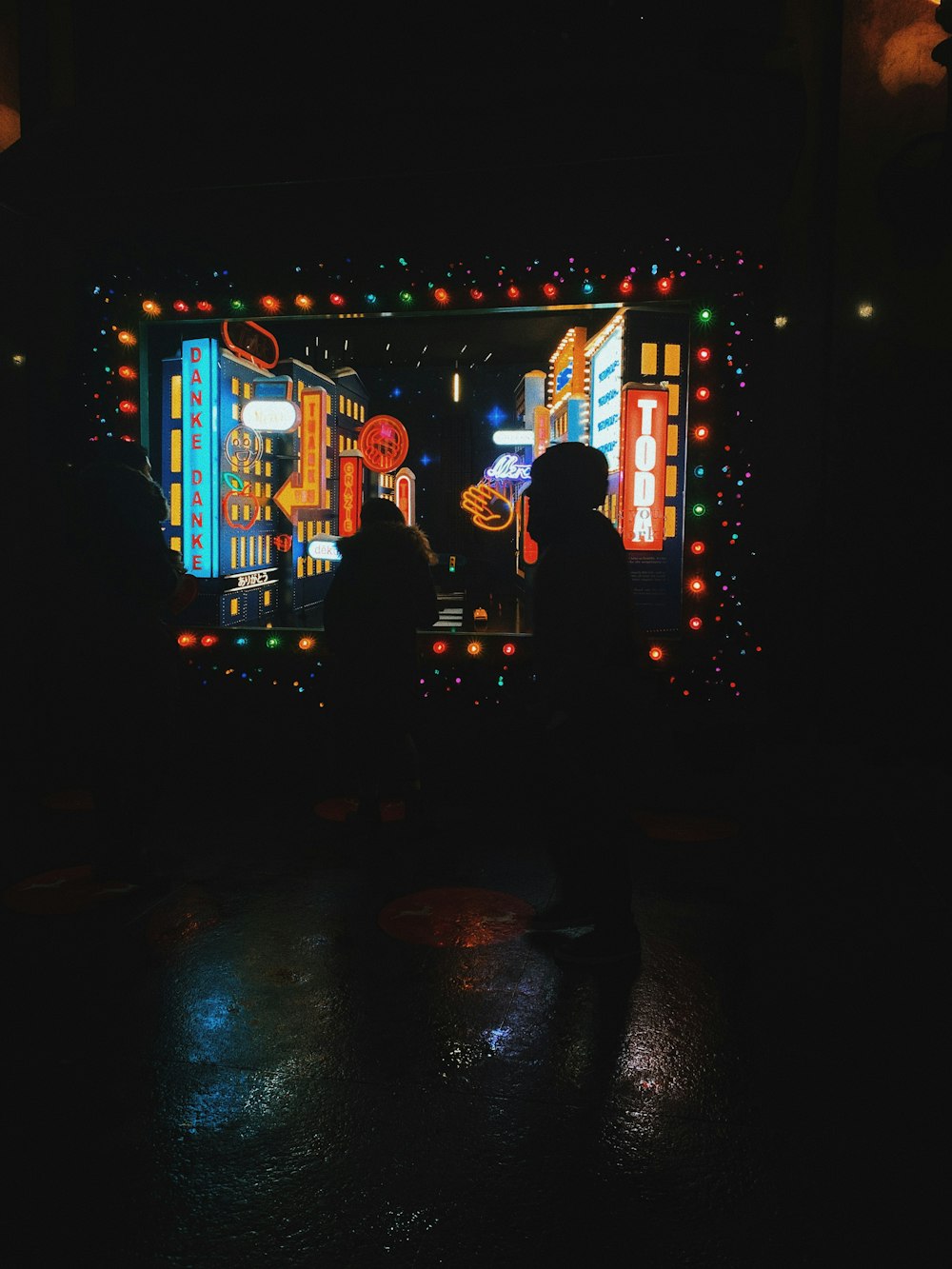 people standing near blue and red lighted building during nighttime