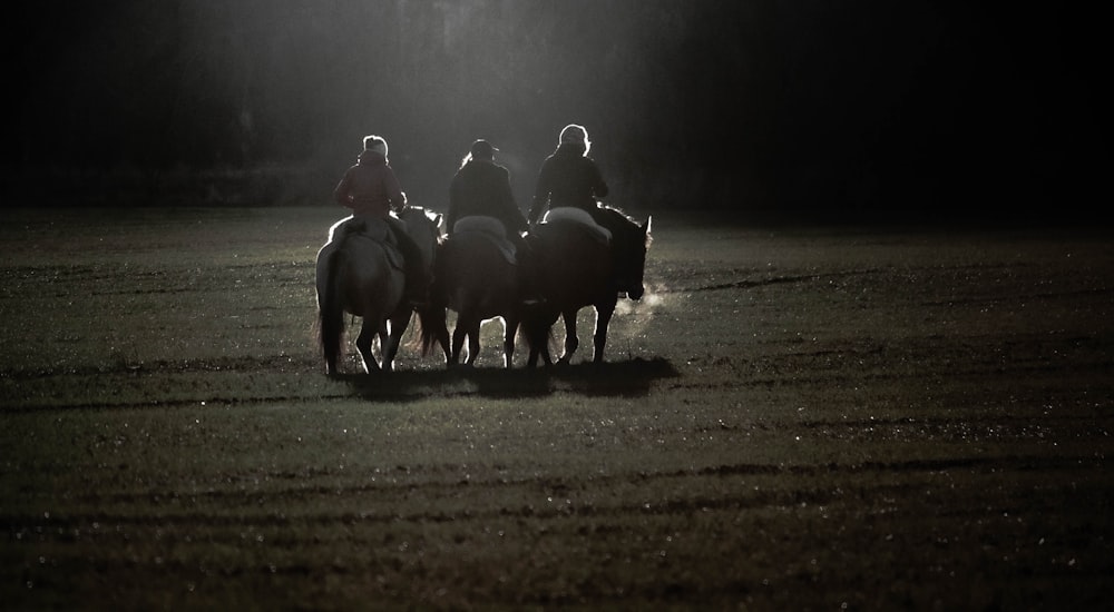 grayscale photo of people riding horses