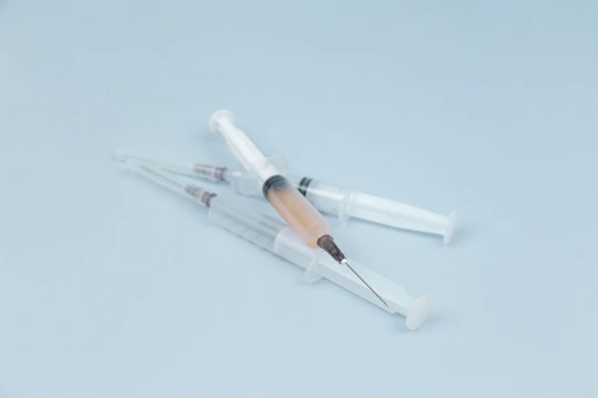Close-up of sterile injectable vials and syringes arranged neatly on a clean surface.