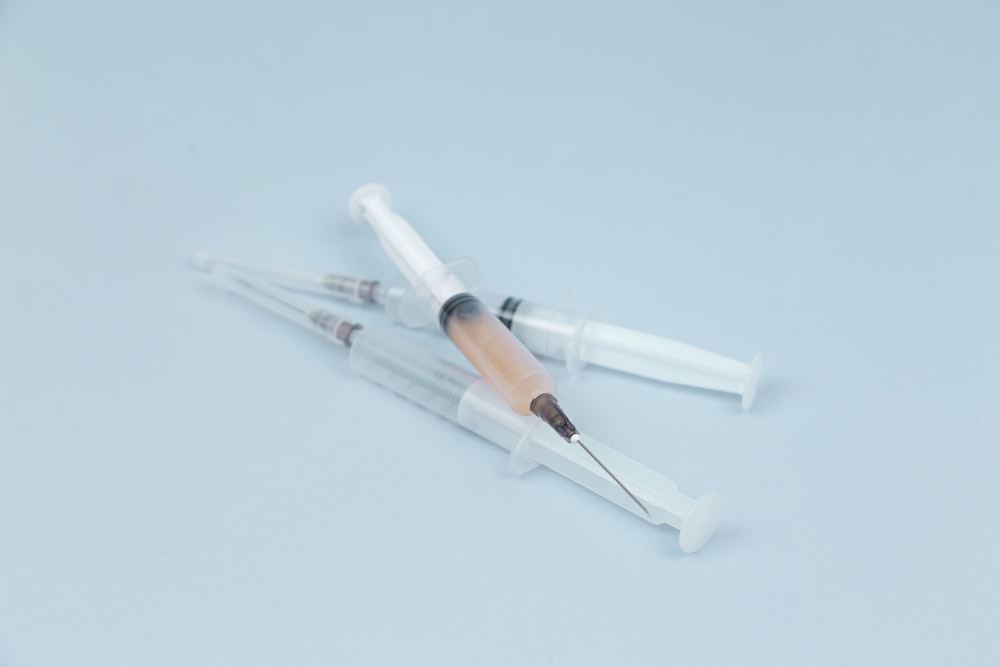 white and clear plastic syringe