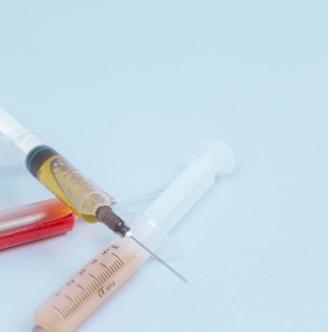 white and orange syringe on white surface