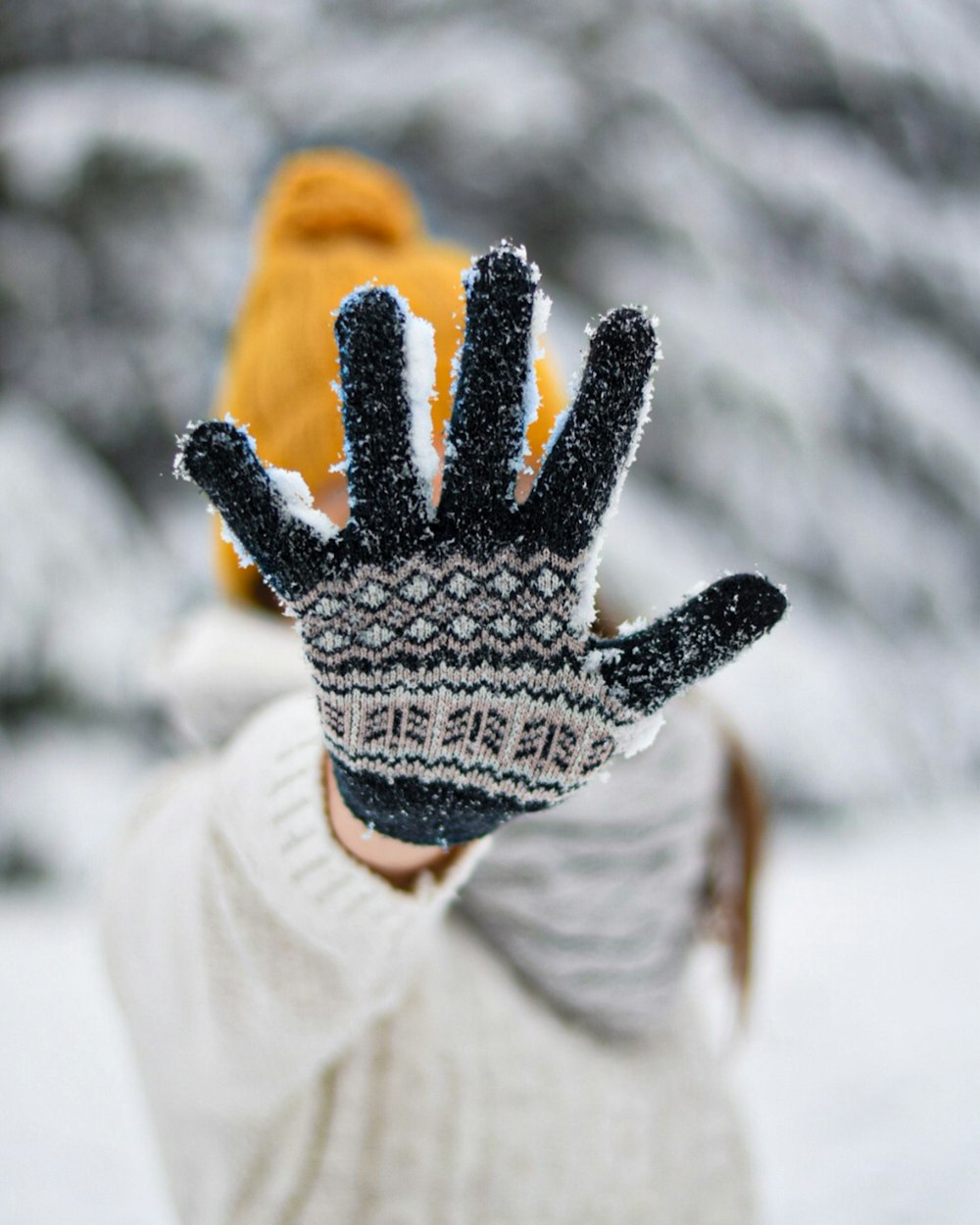 person in white and black knit gloves