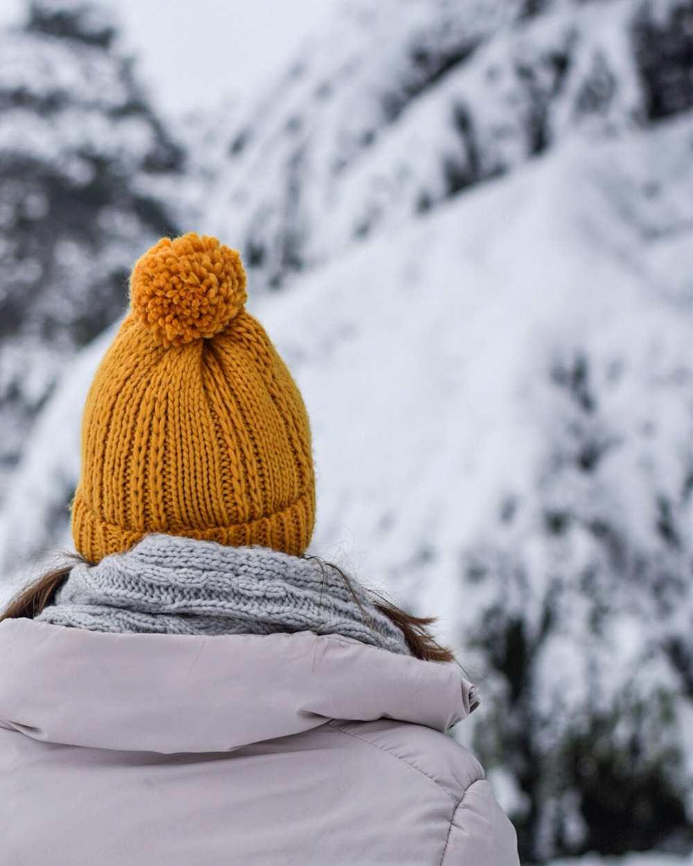 person in brown knit cap and white scarf