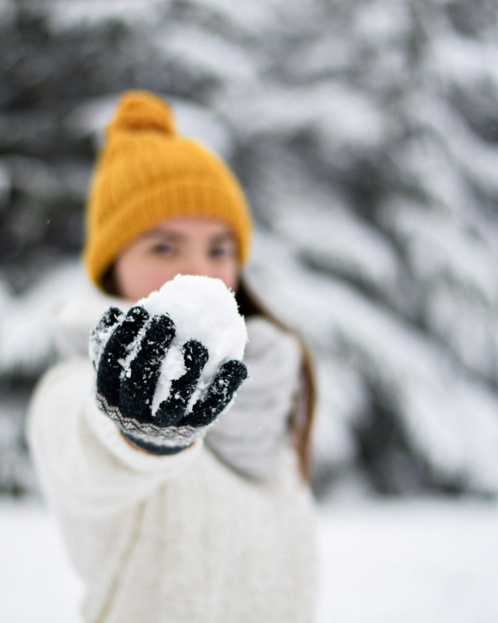 Niño con suéter blanco y gorro de punto naranja