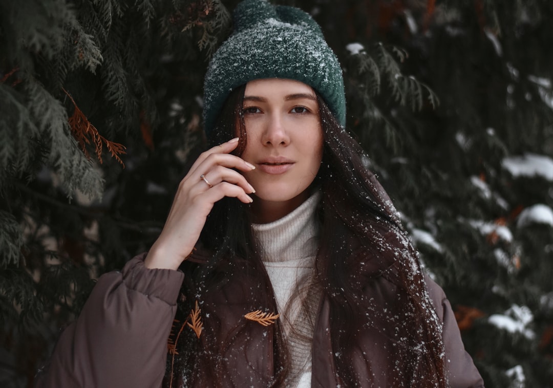 woman in black jacket and green knit cap