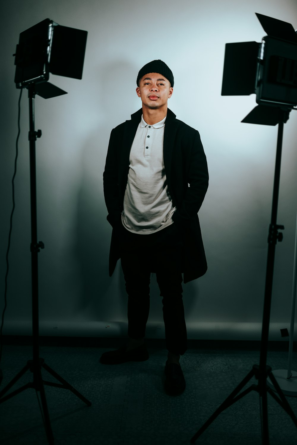 man in black vest standing near black floor lamp