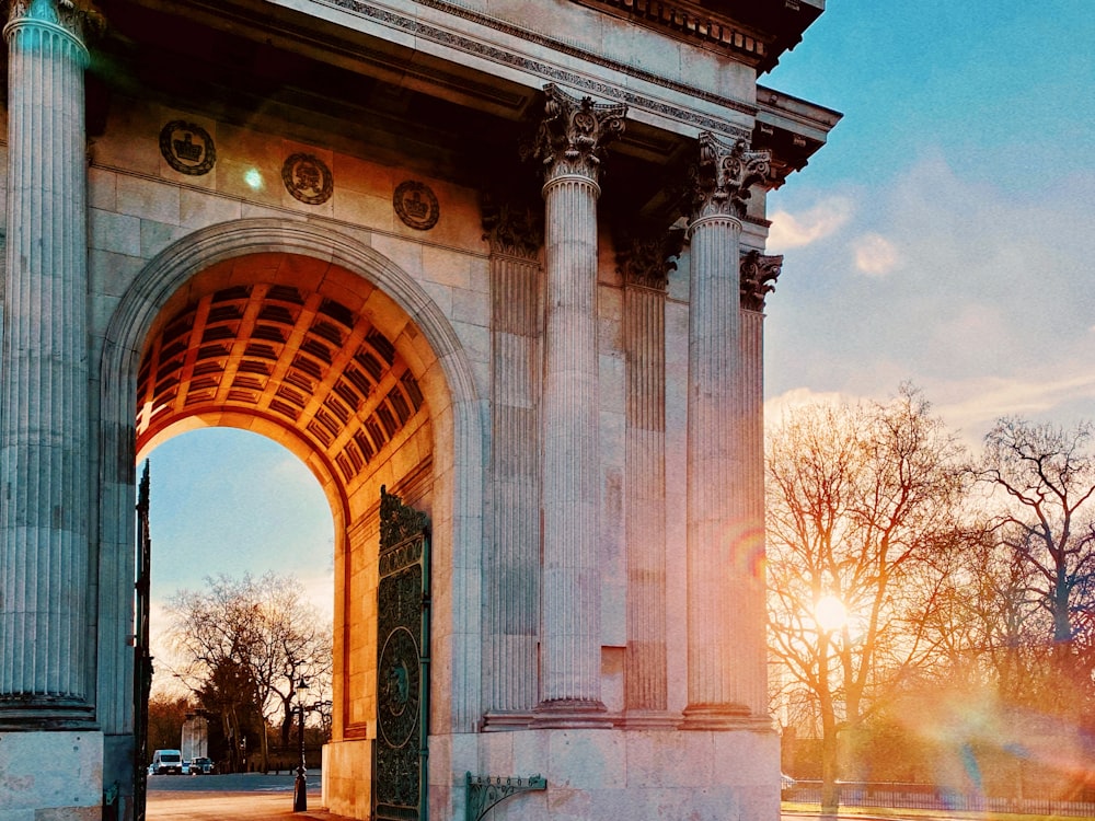 brown concrete arch near bare trees during daytime